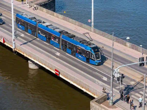Blauer Straßenbahnzug fährt über eine Brücke, auf dem Weg von Görlitz nach Breslau.