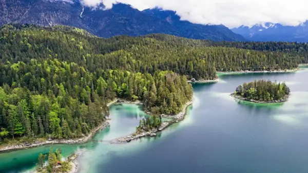 Idyllischer Bergsee mit Inseln, umgeben von dichten Wäldern. Perfekt für einen erfrischenden Tag zum schwimmen.