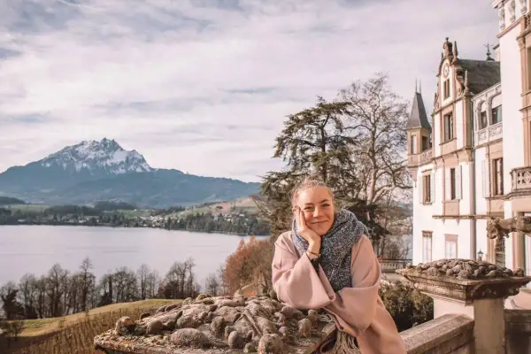 Frau genießt Aussicht auf See & Berge bei Luzern. Entdecke Luzern Geheimtipps von diesem malerischen Ort aus.