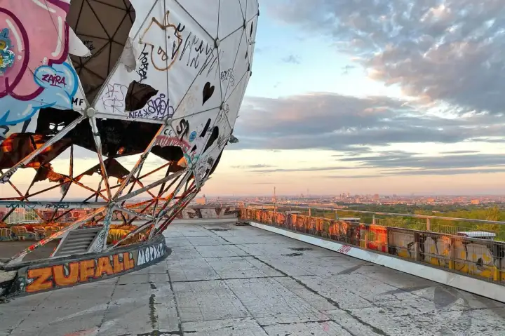 Graffiti-bedeckte Kuppel des Teufelsberg Berlin mit Blick auf die Stadt bei Sonnenuntergang.